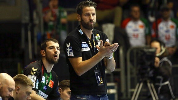 v.l. Bennet Wiegert Magdeburg, Trainer, applaudiert seinen Spielern.