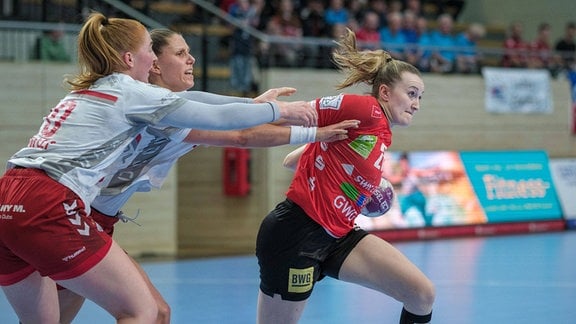 Handballspielerinnen Sofia Hvenfelt (BBM, 20) und Xenia Smits (BBM, 22) versuchen Cara Reuthal (Halle, 26)zu stoppen.