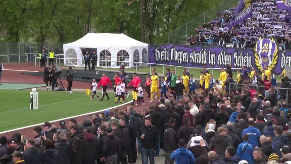 Die Mannschaften laufen ins gefüllte Stadion ein.