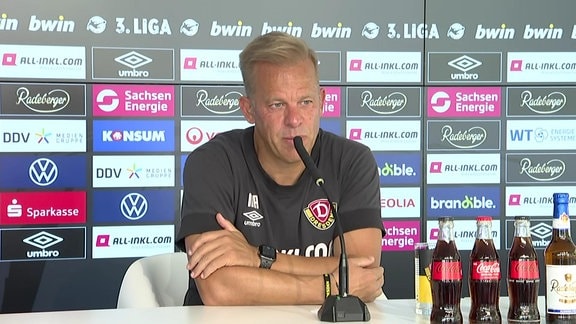 Dynamo-Trainer Markus Anfang vor einer Werbebande auf einer Pressekonferenz