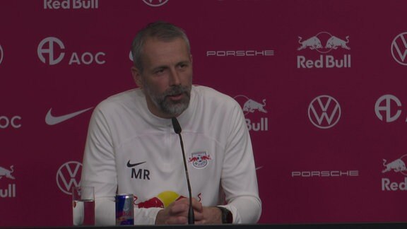 RB-Leipzig-Trainer Marco Rose auf einer Pressekonferenz vor einer Werbebande