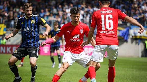 Tunay Deniz am Ball (Hallescher FC), Lucas Halangk (Nummer 16 Hallescher FC). Im Hintergrund Richard Neudecker (1.FC Saarbrücken)