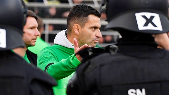 Trainer Miroslav Jagatic diskutiert vor einer Polizeitkette, nach dem Spiel Lok Leipzig gegen Chemie Leipzig 16.10.2022.