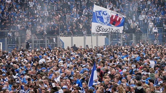 Fans feiern nach Abpfiff auf dem Rasen den Aufstieg des FCM in die 2. Bundesliga.