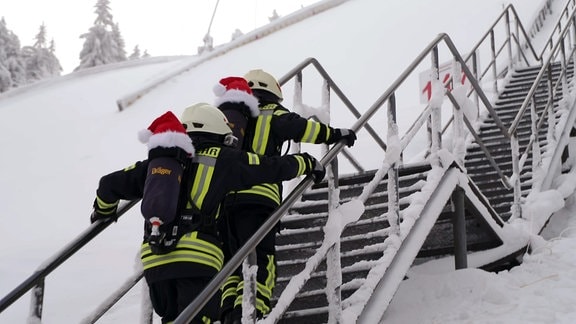 Feuerwehrleute steigen eine Treppe hinauf