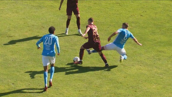 Ein Fußballer foult einen Gegenspieler.