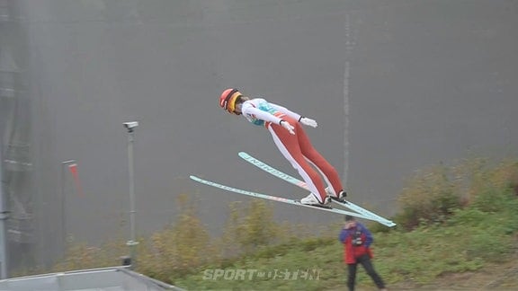 Eine Frau beim Skisprung.