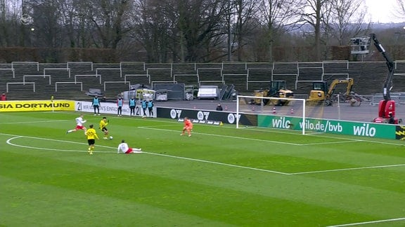 Spieler des BVB spielt den Ball ins Tor.