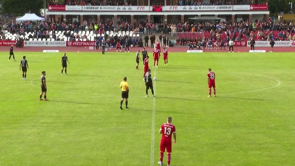 Mannschaften beim Anpfiff auf dem Spielfeld.