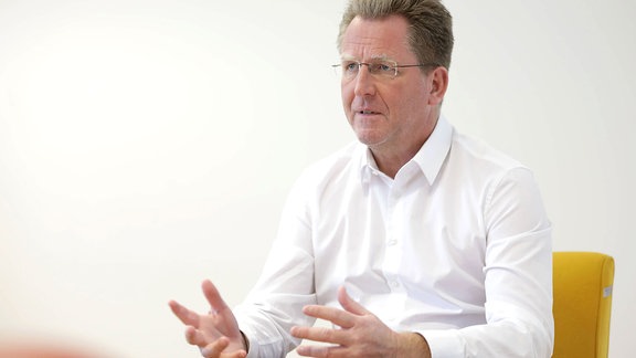 Dr. Stefan Holz , Geschäftsführer der BBL GmbH, spricht während eines Interviews, auf einem Stuhl sitzend.