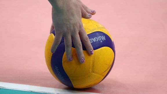 Die Hand einer Spielerin am Volleyball mit Linie.