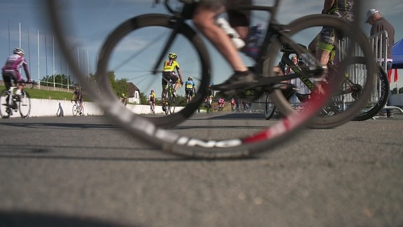 Bei einem Radrennen fahren Fahrräder durch das Bild.