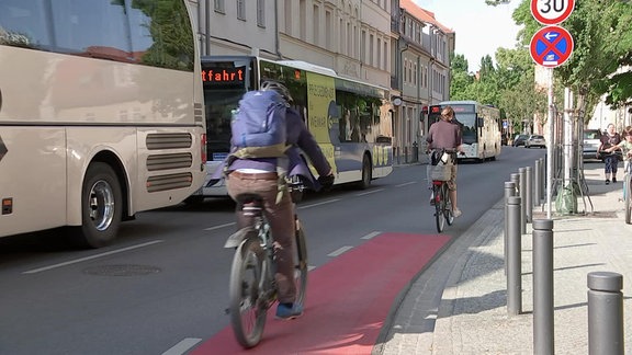 Busse und Radfahrer auf einer Straße