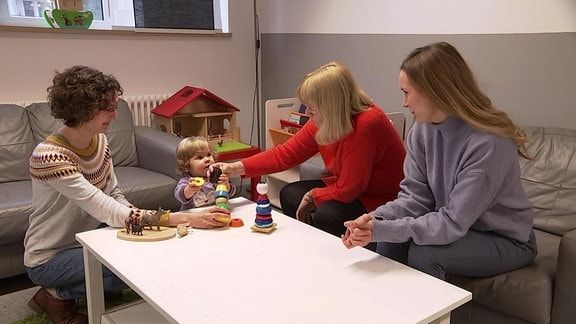 Ein Kleinkind und vier Frauen an einem Tisch