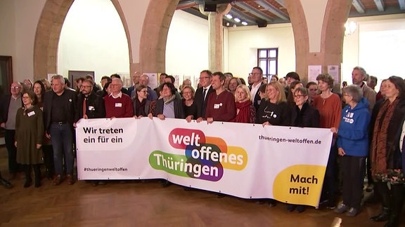 Viele Menschen halten ein Transparent mit dem Logo "weltoffenes Thüringen"