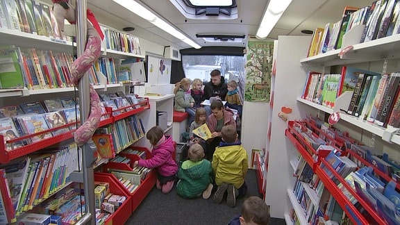 Kinder sitzen in Fahrbibliothek