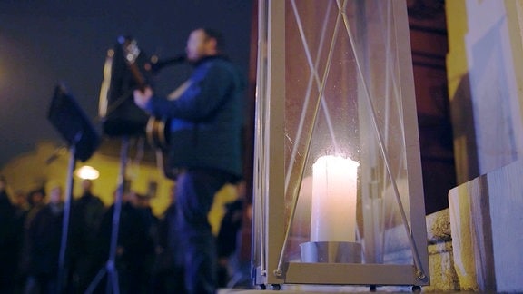 Kerze im Vordergrund, Musiker unscharf im HG