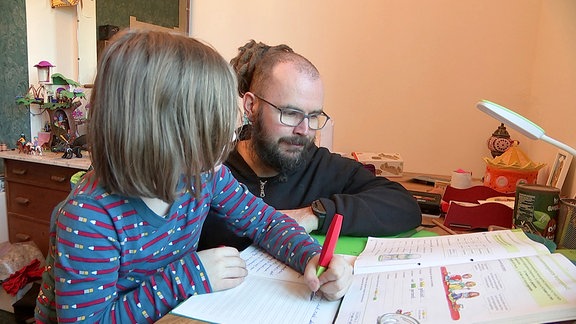 Vater hilft Tochter bei Hausaufgaben