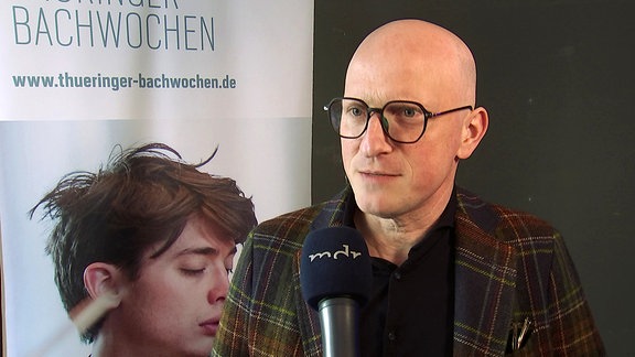 Festivalleiter Christoph Drescher vor einem Plakat der Thüringer Bachwochen 