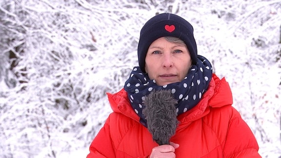 Wettermoderatorin Sandra Voigtmann vor verschneiten Bäumen