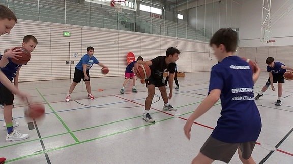 Schüler spielen im Feriencamp Basketball