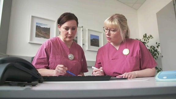 Zwei Krankenschwestern unterhalten sich.