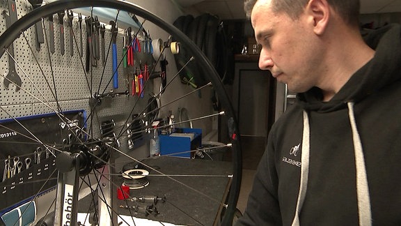 Ein Mann repariert das Rad eines Fahrrads