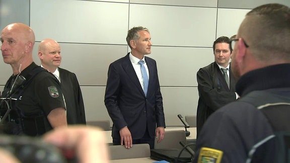 Der Thüringer AFD-Landeschef Björn Höcke als Angeklagter im Gericht, umringt von Polizei und seinen Anwälten 