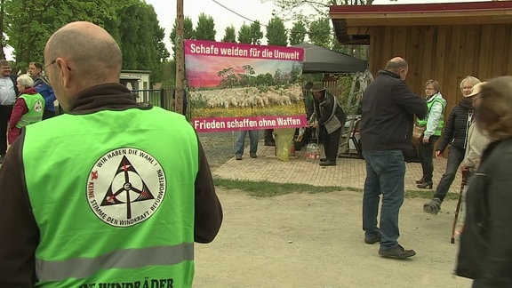 Auf einem Plakat steht: "Schafe weiden für di Umwelt - Frieden schaffen ohne Waffen".
