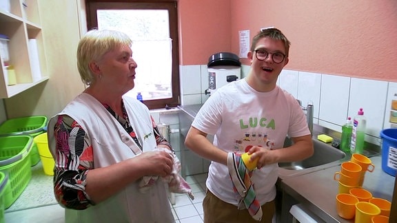 Behinderter Luca beim Abwaschen in Kita-Küche