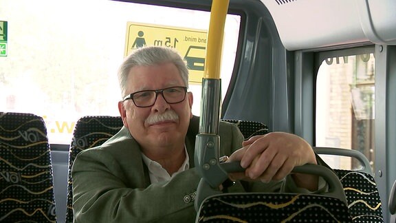 Ein älterer Mann sitzt im Bus