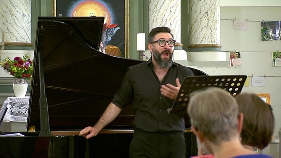 Sänger in einem Kirchenschiff vor einem Klavier