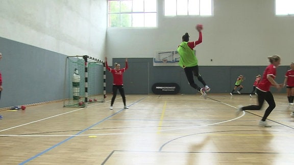Handballerinnen beim Spiel in einer Halle