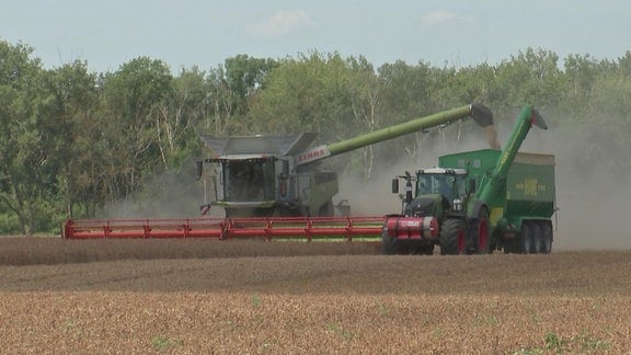 Mähdrescher und Begleitfahrzeug auf einem Feld