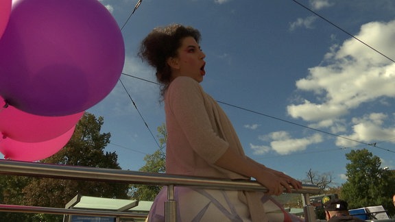 Sängerin auf einem Cabrio-Straßenwagen neben einem Luftballon