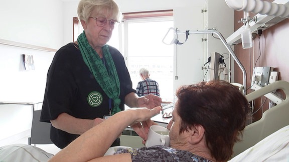 Grüne Dame am Krankenbett