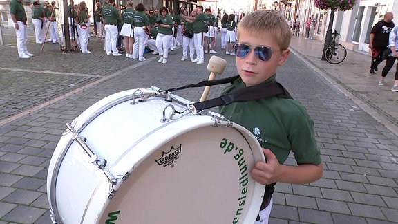 Ein Junge mit einer Pauke vor dem Bauch