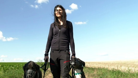 Eine Frau läuft mit zwei Hunden