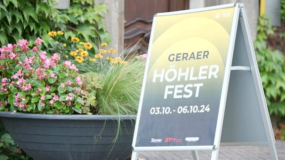 Schild vor Blumenschale