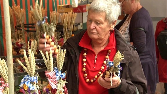 Eine Frau an einem Stand mit Zwiebelzöpfen