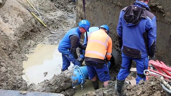 Bauarbeiter an freigelegter Wasserleitung