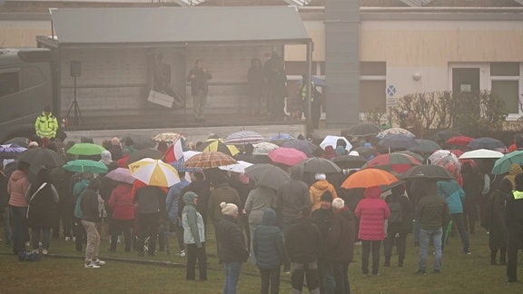 Demonstranten und Demonstrantinnen mit Regenschirmen