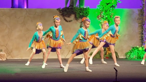 Junge Tänzerinnen in grünen Kostümen auf der Bühne