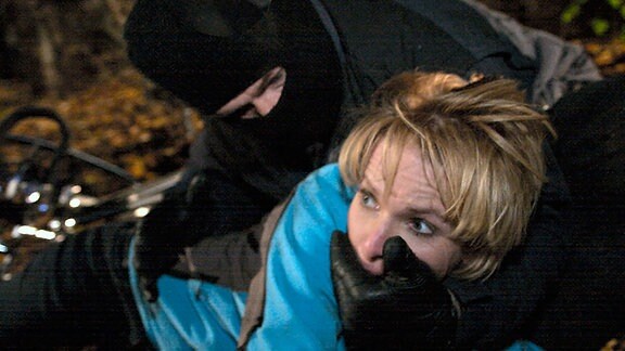 Kathrin (Andrea Kathrin Loewig) wird auf dem Weg nach Hause im Park überfallen. Ein maskierter Mann versucht sie zu vergewaltigen.