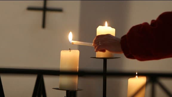 Kerze wird in einer Kirche angezündet