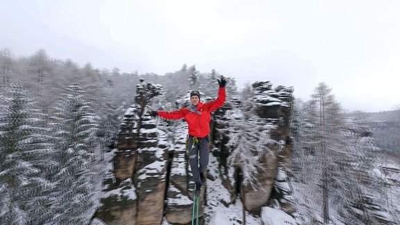 Ein Mann auf einer Zip Line über der Erde im Winter