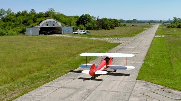 Ein rotes Kleinflugzeug auf einem Flugplatz