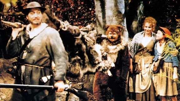 Der Vater (Horst Kube), der Fuchs (Harald Engelmann), die Mutter (Helga Raumer) und Rotkäppchen (Blanche Kommerell) (v. l. n. r.) tragen den besiegten Wolf fort. 