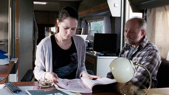 Als Kris (Iris Becher) nach Jahren der Abwesenheit das Fahrgeschäft übernimmt, prüft sie die Bücher ihres Vaters (Waldemar Hooge).
