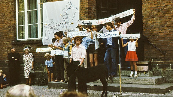Kinder mit Transparenten vor Kinderheim in Calbe, 80er-Jahre.